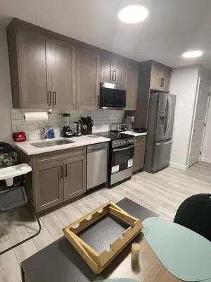 a kitchen with wooden cabinets and stainless steel appliances at Cozy and modern two bedroom guest suite in Calgary
