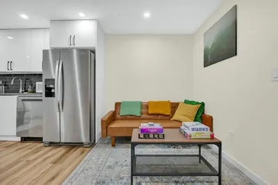 a living room with a couch and a refrigerator at Brand New Private Secondary Suite in Mahogany in Calgary
