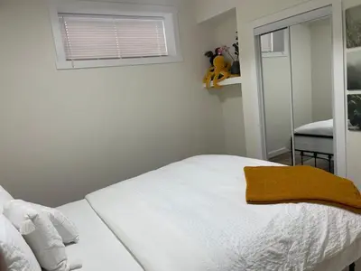 a white bed in a room with a window at Brand New Private Secondary Suite in Mahogany in Calgary