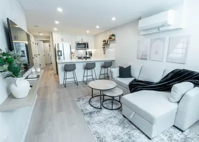 a living room with a couch and a table and a kitchen at YYC Retreat - Near Mountains & Airport in Calgary