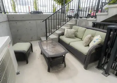 a couch and two chairs and a table on a balcony at YYC Retreat - Near Mountains & Airport in Calgary