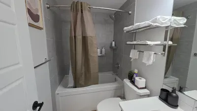 a bathroom with a shower and a toilet and a sink at Modern 2BR Suite in Seton, Calgary in Calgary