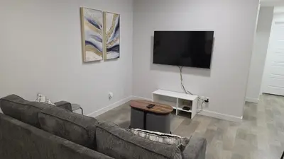 a living room with a couch and a flat screen tv at Modern 2BR Suite in Seton, Calgary in Calgary