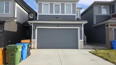 a garage with a white garage door in front of a house at Modern 2BR Suite in Seton, Calgary in Calgary