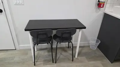 a black table with two black chairs in a kitchen at Modern 2BR Suite in Seton, Calgary in Calgary