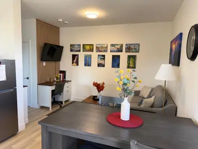 a living room with a table with a vase of flowers on it at Modern 1BR Suite with Laundry, Workspace & WiFi in Langford