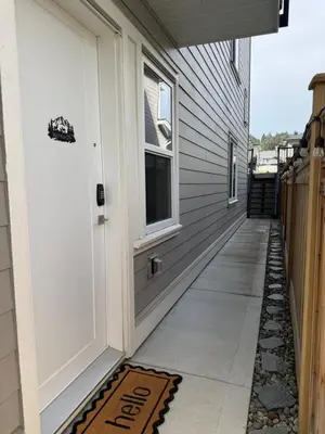 a walkway leading to a house with a door at Modern 1BR Suite with Laundry, Workspace & WiFi in Langford