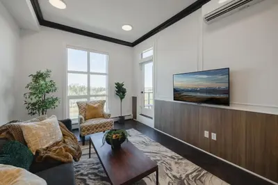 a living room with a tv on a wall at Walk University District, Near Hospitals & Shops in Calgary