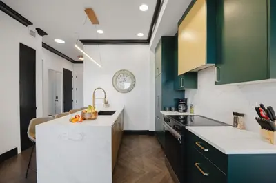a kitchen with green cabinets and a white counter top at Walk University District, Near Hospitals & Shops in Calgary