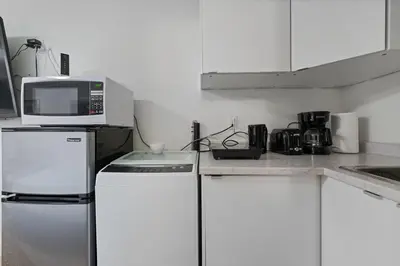a kitchen with a microwave on top of a refrigerator at Renovated North Vancouver Gem in North Vancouver