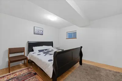 a bedroom with a black bed and a chair at Renovated North Vancouver Gem in North Vancouver
