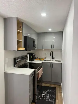 a kitchen with gray cabinets and a sink at Serenity Suite 3603 in Edmonton