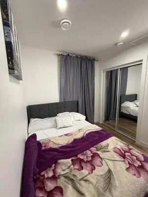 a bedroom with a bed with a flower blanket on it at Serenity Suite 3603 in Edmonton