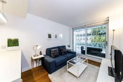 a living room with a blue couch and a large window at Corporate Stays Telus Gardens 1 Bedroom in Vancouver