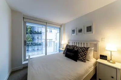 a bedroom with a bed and a large window at Corporate Stays Telus Gardens 1 Bedroom in Vancouver