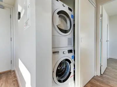 a washer and dryer in a white laundry room at Corporate Stays Hazel 1 Bedroom in Burnaby