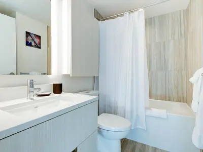 a bathroom with a sink and a toilet and a tub at Corporate Stays Hazel 1 Bedroom in Burnaby