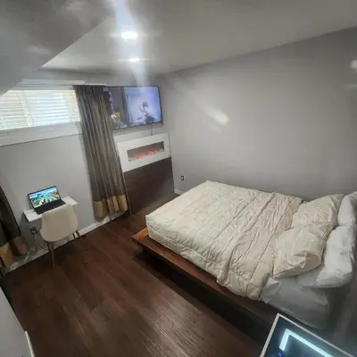a bedroom with a bed and a tv on the wall at beautiful private house in Edmonton