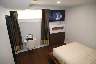 a bedroom with a bed and a tv on the wall at beautiful private house in Edmonton