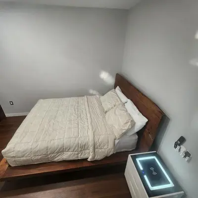 a bedroom with a bed with a wooden headboard at beautiful private house in Edmonton