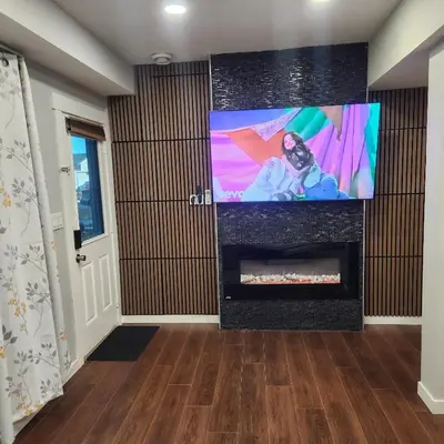 a living room with a large screen tv and a fireplace at beautiful private house in Edmonton