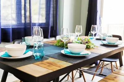 a wooden table with bowls and wine glasses on it at 5BDRM Bright Modern Home-King Bed-Garage-Sleeps 12 in Edmonton
