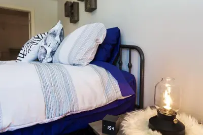 a bed with blue and white pillows and a lamp at 5BDRM Bright Modern Home-King Bed-Garage-Sleeps 12 in Edmonton