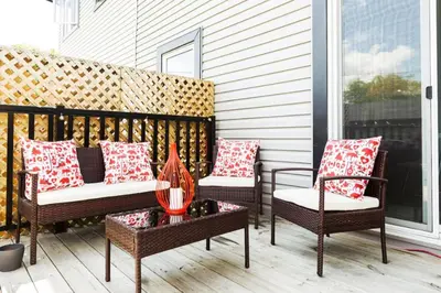 three chairs and a table on a porch at 5BDRM Bright Modern Home-King Bed-Garage-Sleeps 12 in Edmonton