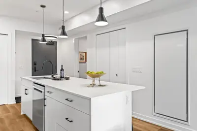 a kitchen with white cabinets and a counter with a bowl of fruit at 3BR Mountain Bliss Retreat with Gym Hot Tub and Sauna in Canmore