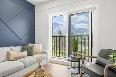a living room with a couch and a large window at Modern 4BR Mountain Retreat Balcony BBQ near DT in Canmore