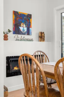 a dining room with a table and chairs and a fireplace at Modern 4BR Mountain Retreat Balcony BBQ near DT in Canmore