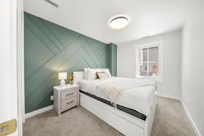 a bedroom with a bed with a green accent wall at Modern 4BR Mountain Retreat Balcony BBQ near DT in Canmore