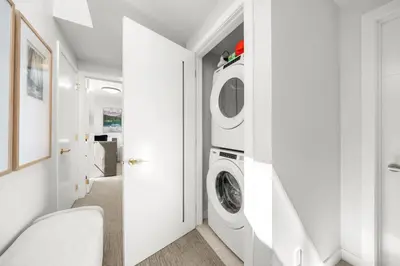 a white laundry room with a washer and dryer at Modern 4BR Mountain Retreat Balcony BBQ near DT in Canmore