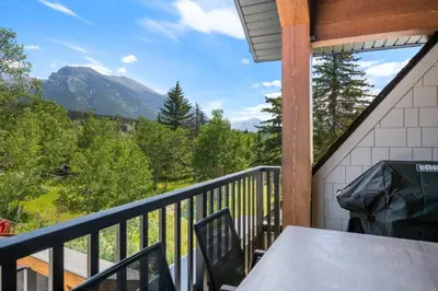 a balcony with a table and a view of a mountain at Modern 4BR Mountain Retreat Balcony BBQ near DT in Canmore