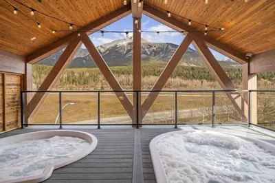 two hot tubs on a deck with a mountain view at Modern 4BR Mountain Retreat Balcony BBQ near DT in Canmore