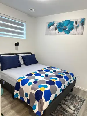 a bedroom with a bed with a blue at Modern Basement Suite near West Edmonton Mall in Edmonton