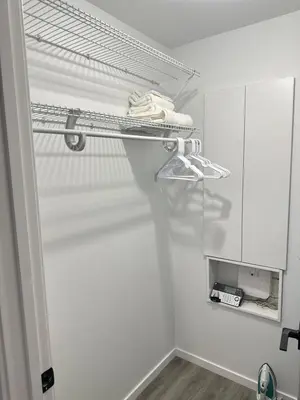 a white bathroom with a towel on a shelf at Modern Basement Suite near West Edmonton Mall in Edmonton