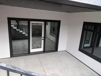 an empty room with a sliding glass door at 21 Greenwich Common NW Calgary Alberta in Calgary