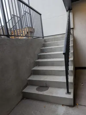 a set of stairs in a building with a railing at 21 Greenwich Common NW Calgary Alberta in Calgary