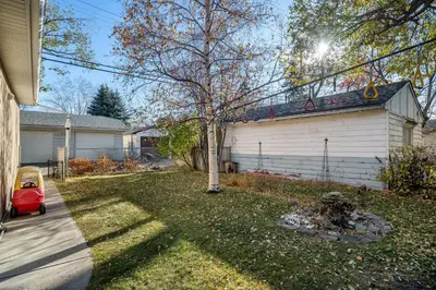 a yard with a tree and a house at Family Friendly Welcoming Basement Suite in Calgary