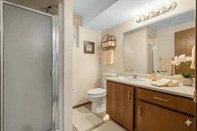 a bathroom with a toilet and a sink and a shower at Family Friendly Welcoming Basement Suite in Calgary