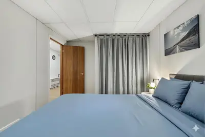 a bedroom with a large bed with blue pillows at Family Friendly Welcoming Basement Suite in Calgary