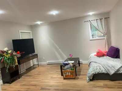 a bedroom with a bed and a flat screen tv at A Cozy 2 beds Suite in Whistle Bend in Whitehorse