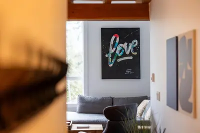 a living room with a couch and a painting on the wall at Fully Renovated Penthouse Loft at Fernie Alpine Resort in Fernie
