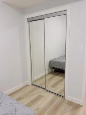 a room with a sliding glass door with a bed at Modern Comfort West Edmonton in Edmonton