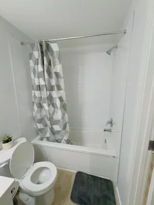 a bathroom with a toilet and a bath tub at Modern Comfort West Edmonton in Edmonton