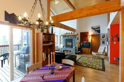 a living room with a table and a fireplace at Pemberton Tree Lodge in Pemberton