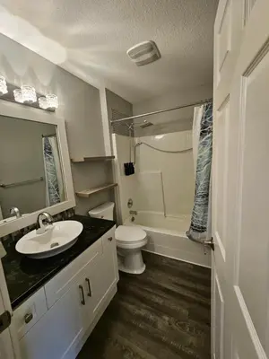 a bathroom with a sink and a toilet and a shower at White-Tail Hollow - 309 - 1105 Henry Rd in Courtenay