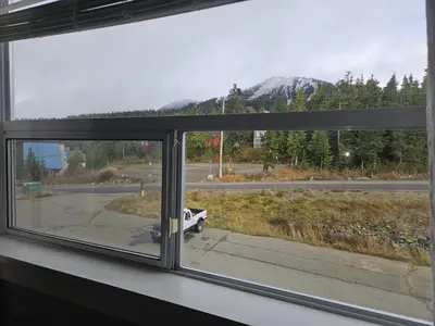 a window with a view of a road and mountains at White-Tail Hollow - 309 - 1105 Henry Rd in Courtenay