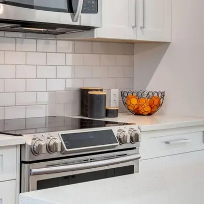 a kitchen with a stove and a bowl of oranges at Stunning Modern 2BR Unit in Downtown Canmore in Canmore